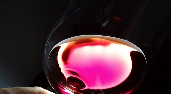 Una copa inclinada de vino rosado